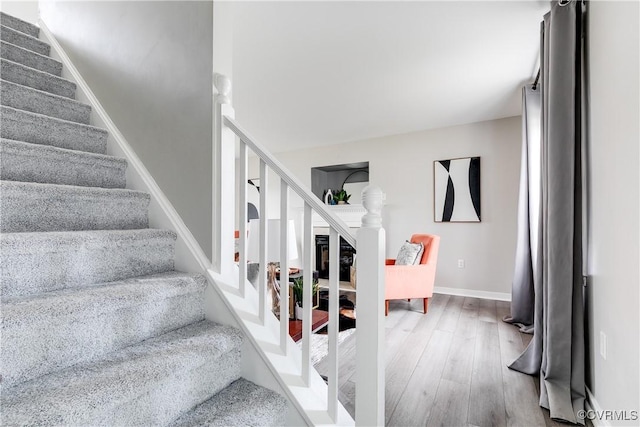 stairway featuring baseboards and wood finished floors