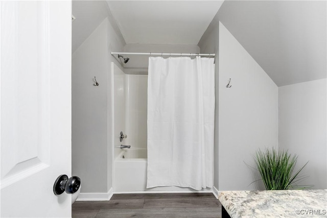 bathroom featuring shower / tub combo, baseboards, and wood finished floors