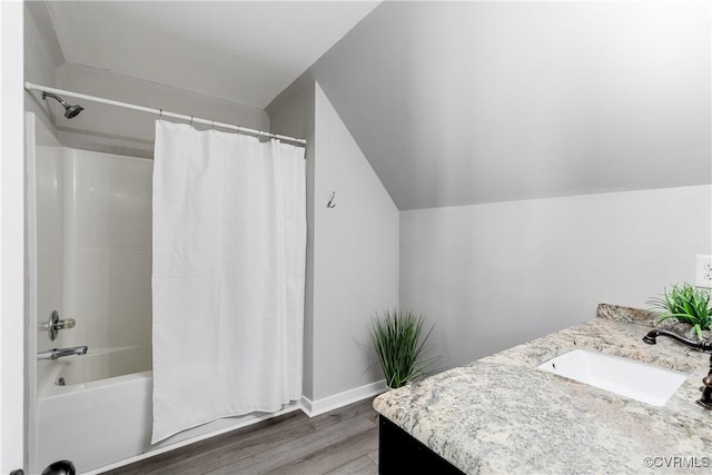 full bathroom featuring shower / bathtub combination with curtain, wood finished floors, baseboards, lofted ceiling, and vanity