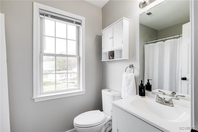 bathroom featuring a shower with shower curtain, visible vents, toilet, and vanity