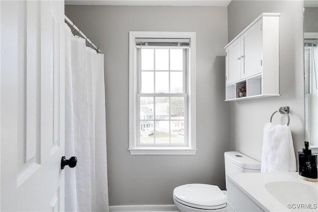 bathroom with vanity, toilet, and a healthy amount of sunlight