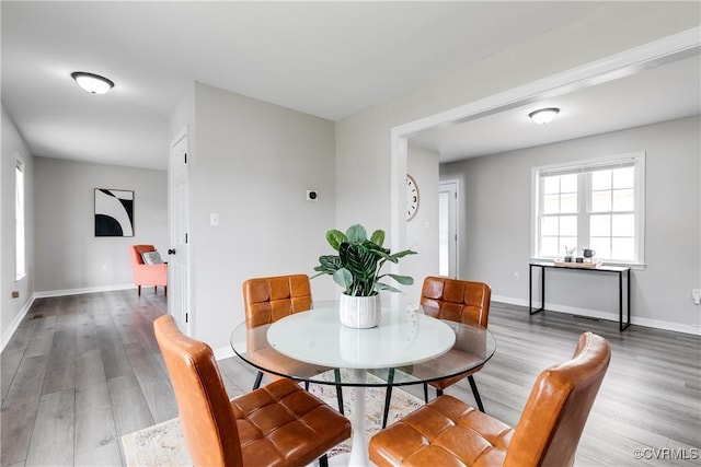 dining space with baseboards and light wood-style floors