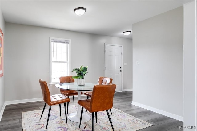 dining space featuring baseboards and wood finished floors