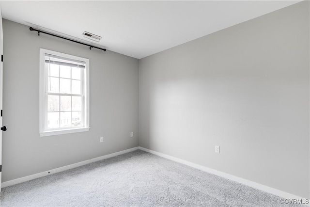 empty room featuring carpet flooring, baseboards, and visible vents