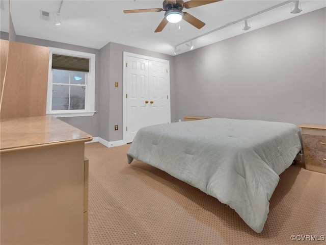 bedroom with a ceiling fan, light colored carpet, visible vents, and track lighting