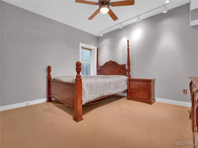 bedroom featuring light carpet, ceiling fan, track lighting, and baseboards