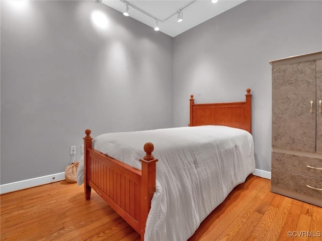 bedroom featuring baseboards and wood finished floors