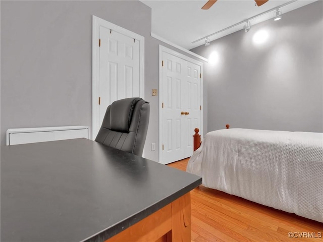 bedroom with a closet, light wood-style flooring, and a ceiling fan