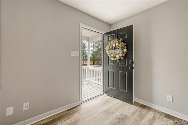 entryway featuring baseboards and light wood finished floors