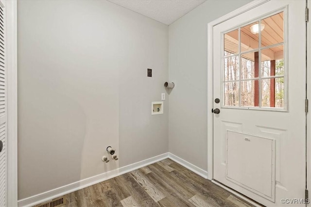 washroom featuring baseboards, laundry area, hookup for a washing machine, wood finished floors, and electric dryer hookup