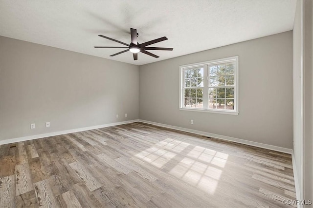 empty room with visible vents, baseboards, wood finished floors, and a ceiling fan