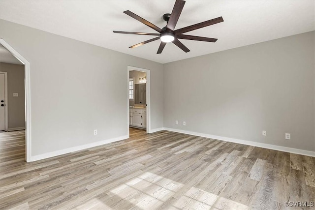 empty room with baseboards, light wood-style floors, and ceiling fan