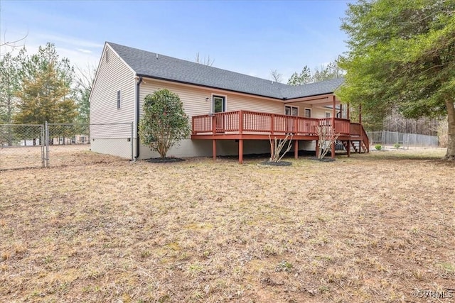 back of property featuring a deck and fence