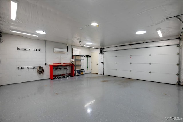 garage featuring a wall mounted air conditioner and concrete block wall