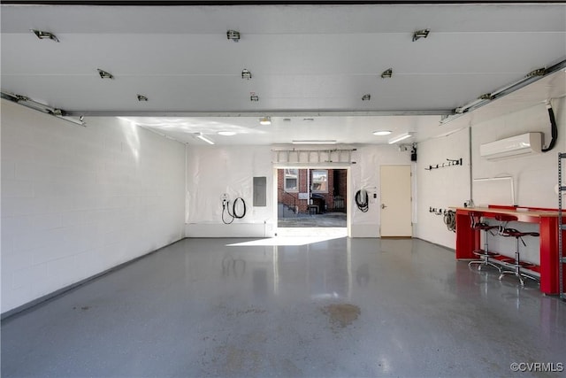 garage with a wall mounted air conditioner and concrete block wall