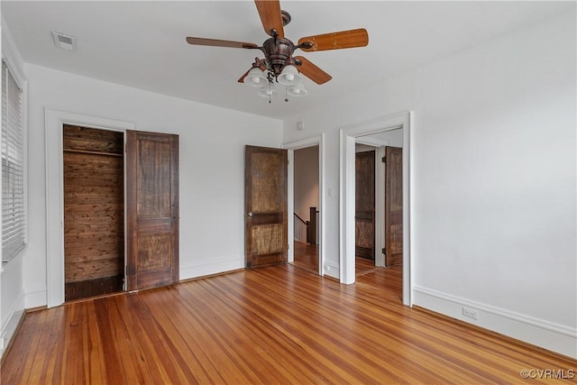 unfurnished bedroom featuring light wood-type flooring, baseboards, visible vents, and a ceiling fan