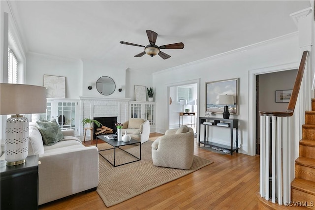 living area with stairway, light wood-style flooring, and ornamental molding