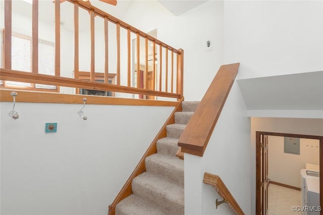 stairway featuring electric panel and washer / clothes dryer