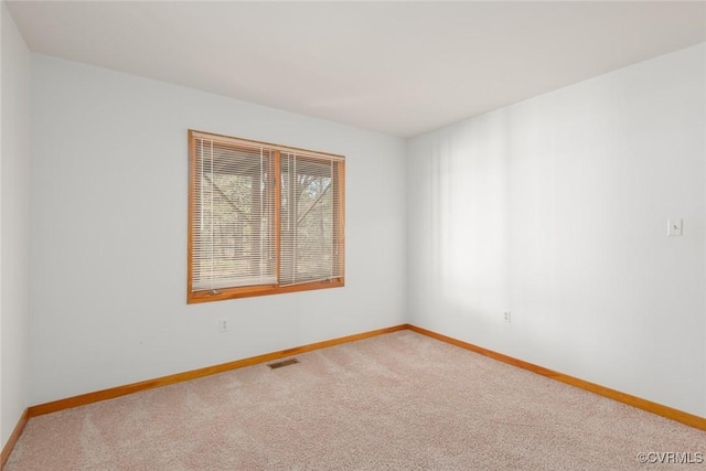 spare room with visible vents, baseboards, and carpet flooring