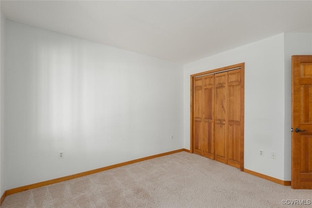 unfurnished bedroom with a closet, baseboards, and carpet floors