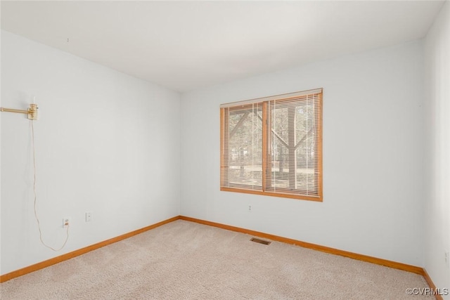 unfurnished room featuring baseboards, light carpet, and visible vents