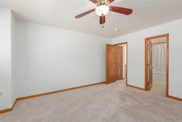 unfurnished bedroom with light carpet, connected bathroom, and baseboards