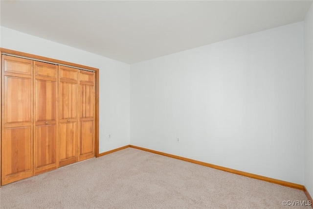 unfurnished bedroom featuring light carpet and baseboards