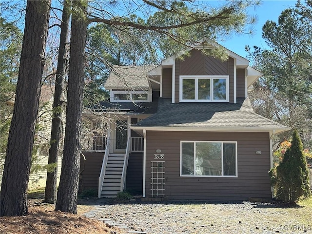 view of front of home with stairway and roof with shingles