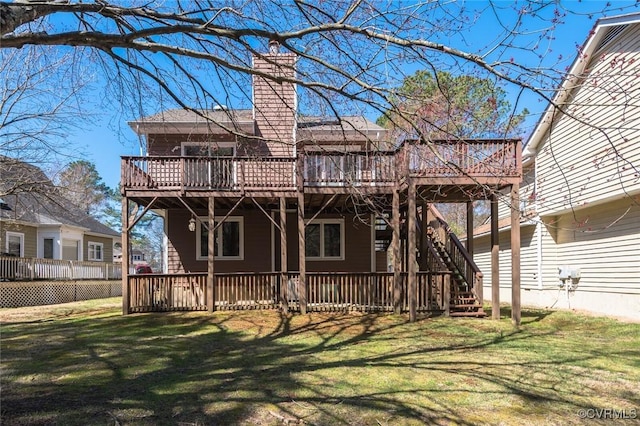 back of property featuring a lawn, a chimney, stairs, and a deck