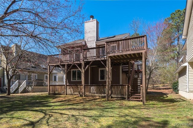 rear view of house with stairs, a yard, a chimney, and a wooden deck