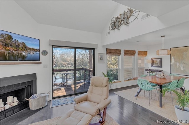 sitting room featuring a fireplace, vaulted ceiling, wood finished floors, and visible vents