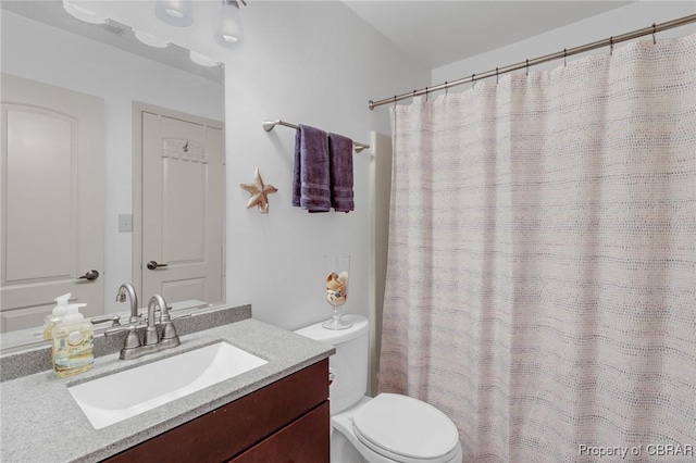 bathroom with toilet, vanity, and a shower with curtain