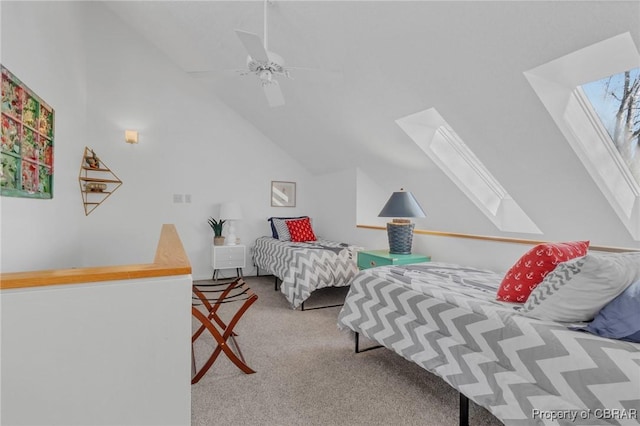 carpeted bedroom featuring vaulted ceiling with skylight and ceiling fan