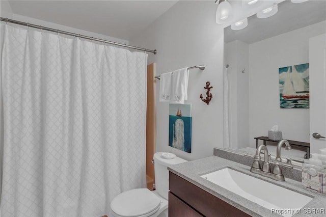 full bath featuring a shower with shower curtain, toilet, and vanity