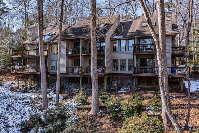 rear view of property featuring roof with shingles and a chimney