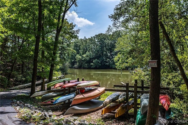 view of dock featuring a forest view and a water view