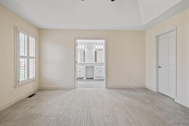 unfurnished room featuring carpet floors, visible vents, baseboards, and a ceiling fan