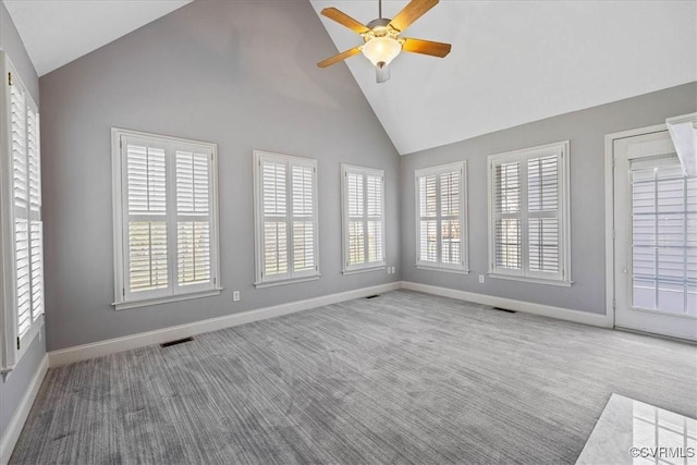 carpeted empty room with a healthy amount of sunlight, visible vents, and baseboards