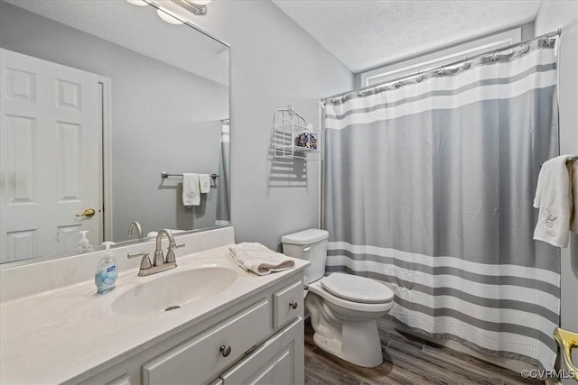 bathroom featuring vanity, a textured ceiling, toilet, and wood finished floors