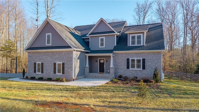 craftsman-style home featuring brick siding, roof with shingles, and a front yard