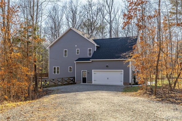 view of front facade featuring roof with shingles and driveway