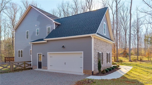 view of home's exterior with a shingled roof, fence, a lawn, driveway, and an attached garage