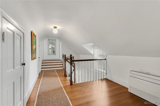 additional living space featuring lofted ceiling, baseboards, and light wood finished floors