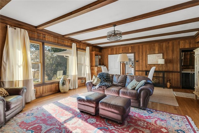 living room with wood walls, wood finished floors, and beam ceiling