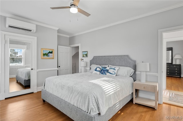 bedroom with ornamental molding, wood finished floors, ceiling fan, and a wall mounted AC