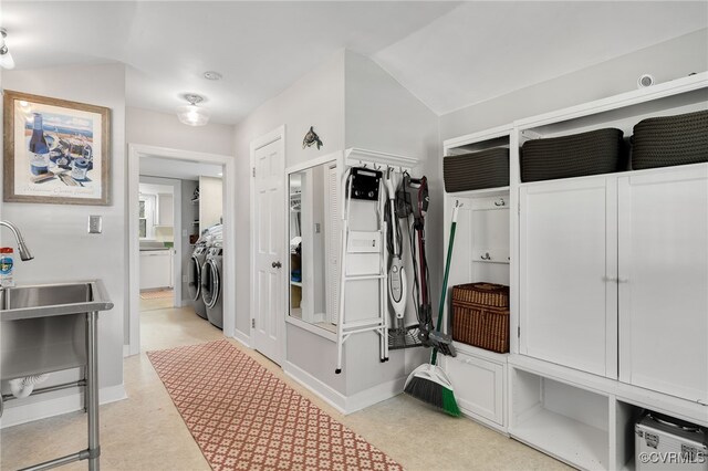 mudroom with lofted ceiling, baseboards, and washer and dryer