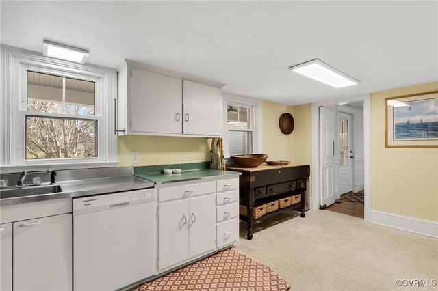 kitchen featuring baseboards, white cabinetry, white dishwasher, and a sink