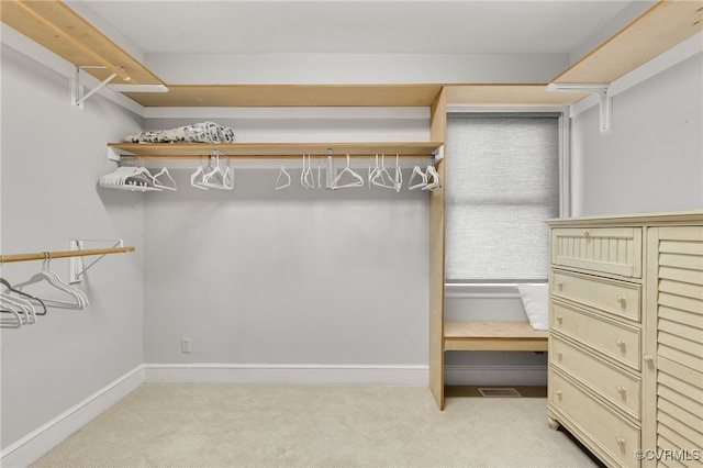 walk in closet with light colored carpet