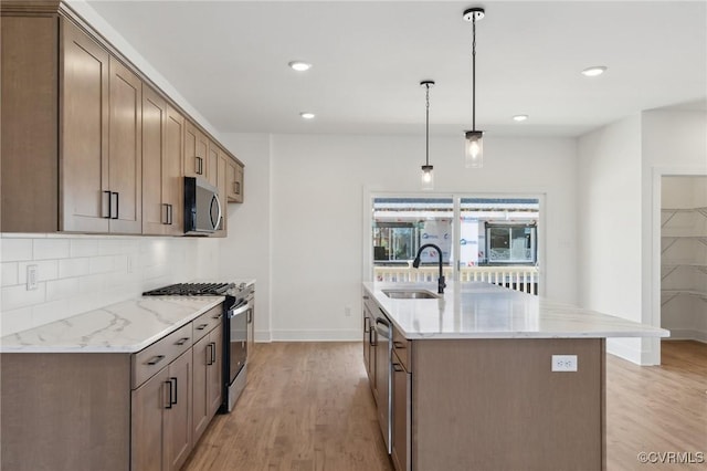 12149 Morning Walk, Henrico, VA 23233 - kitchen with appliances with stainless steel finishes, a sink, light wood-style flooring, tasteful backsplash, and light stone countertops