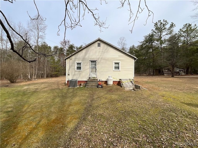 rear view of property featuring entry steps and a yard